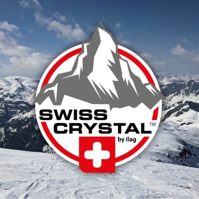 Snowy mountains in the background. In the foreground on white ground a imitation of the Matterhorn in grey. Swiss crystal lettering in black in the middle and the Swiss Cross underneath. The logo is rounded off with a red frame.