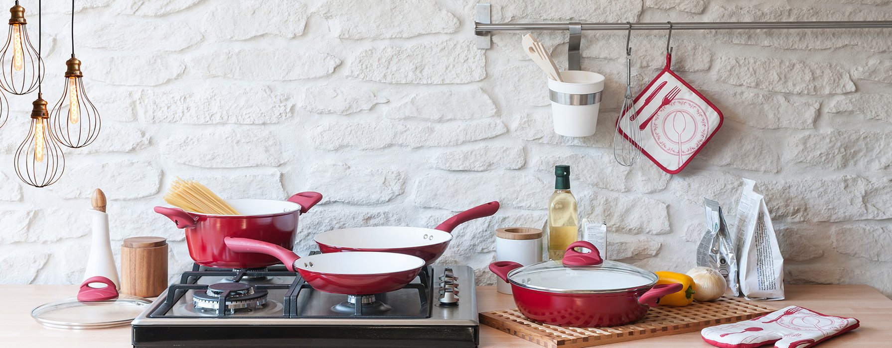 Different pans and pots are draped in a kitchen. In different sizes and varnished in red on the outside. The inside coating is white.