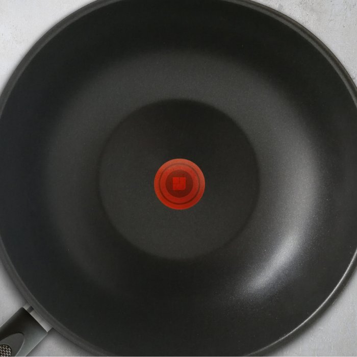 Black coated inside of a frying pan with a red temperature point in the middle