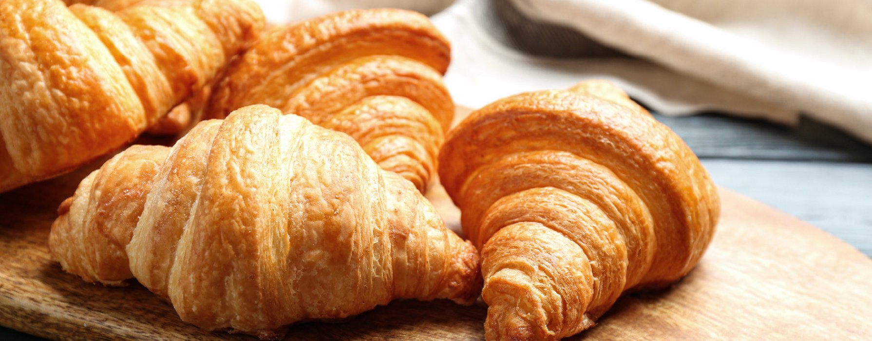 Aufgebackene Butter Croissants auf einem Holzbrett