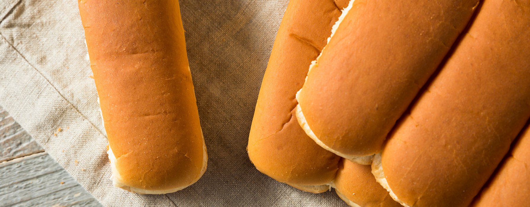 Aufgeschnittene Hot-Dog-Brötchen gefüllt mit einer Frischkäsemasse