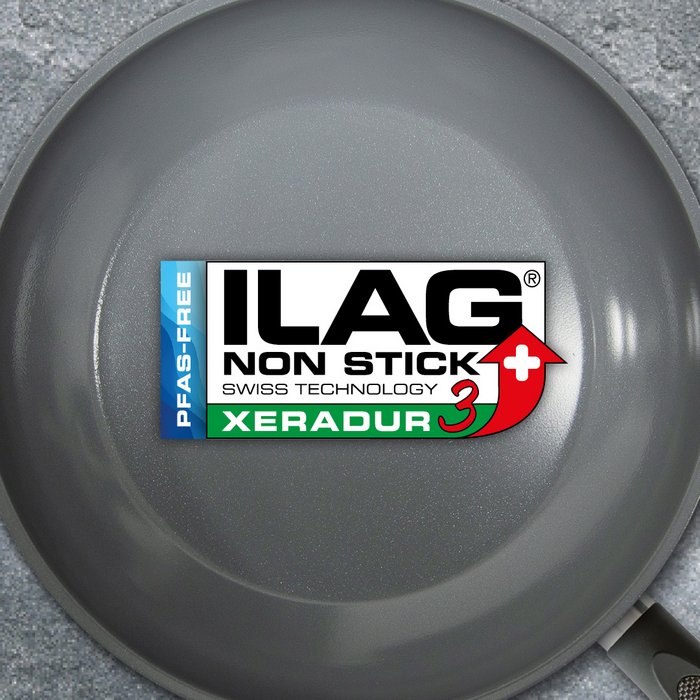 Grey glossy inside of a frying pan - ILAG logo with dark green shaded Xeradur 3 lettering in the center and on the left hand side an extra labeling "PFAS-FREE" in blue