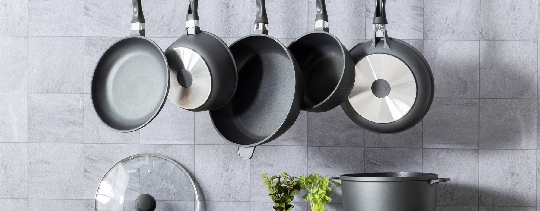 Hanging frying pan assortment in different sizes in a modern kitchen